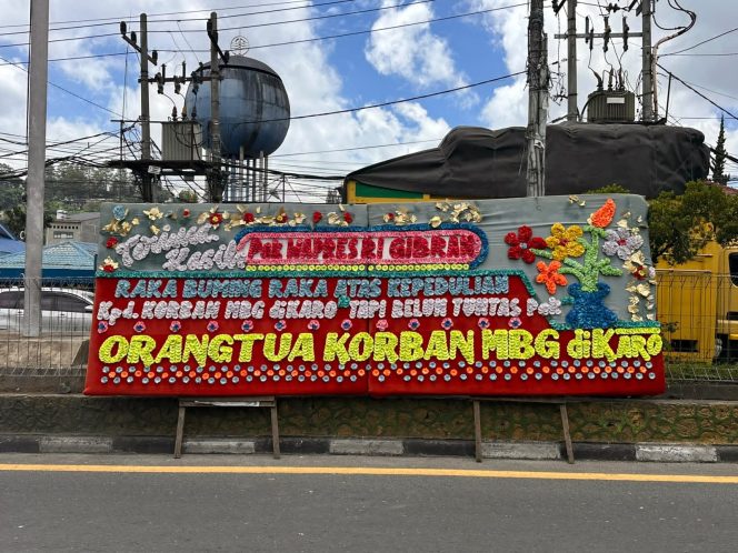 
					” Orangtua Siswa Keracunan MBG Di Karo Kirim Pesan Ke Wapres RI Lewat Papan Bunga Di Tugu Perjuangan Berastagi”